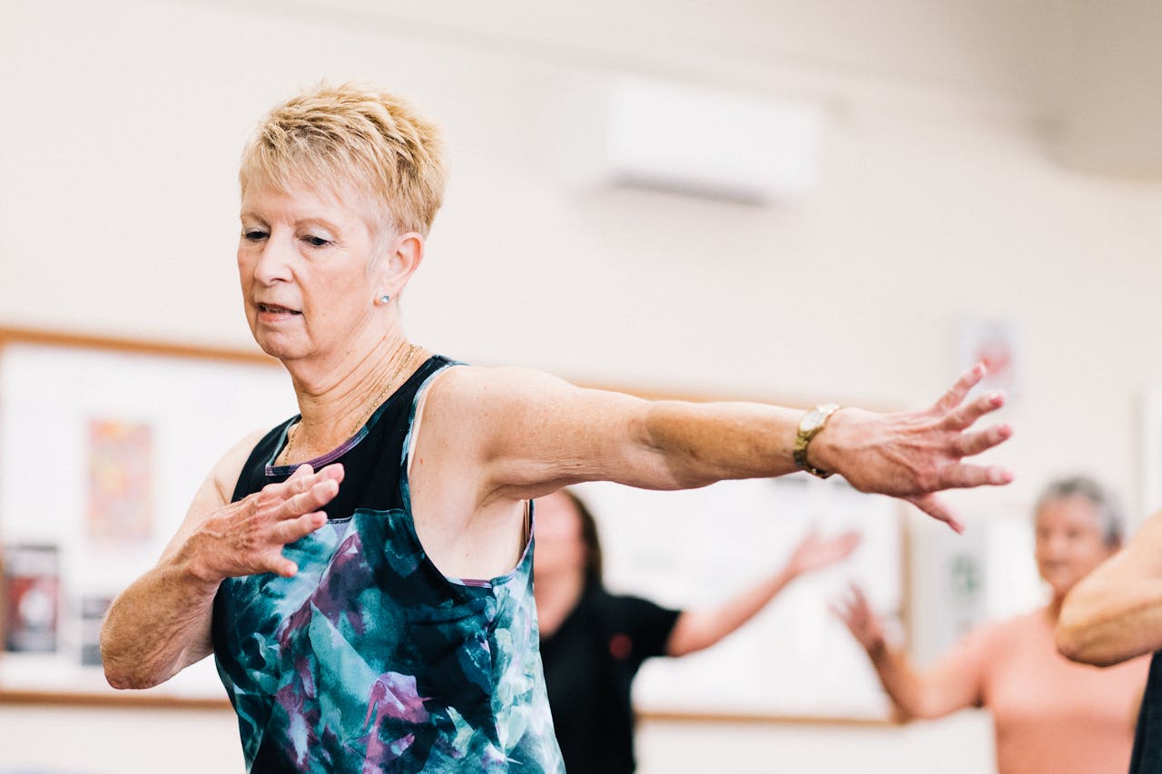 home-img Senior woman participating in a lively fitness class indoors, embracing positive aging.